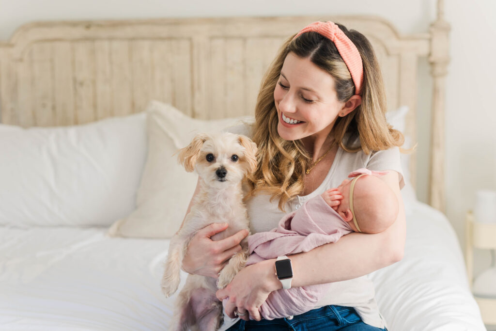 Mom holding newborn and dog at Columbus Twin Newborn Photography session