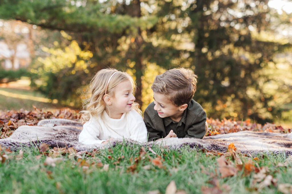 a brother and sister looking at each other during a mini session

