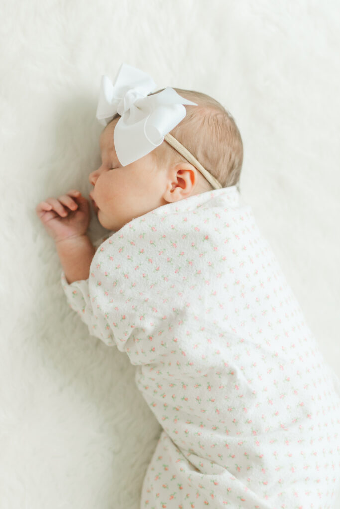 a baby is sleeping on her side during a session with a newborn photographer in columbus, ohio