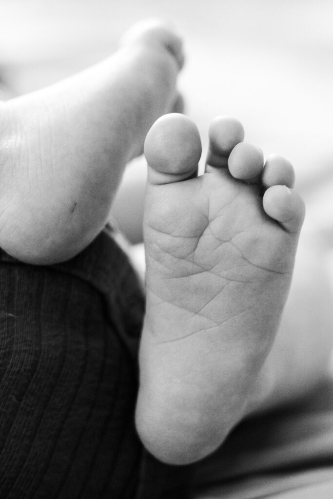 an up-close photo of a baby's feet in black and white
