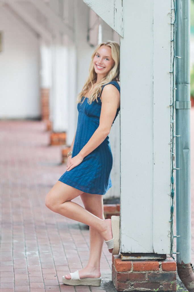 a senior girl posing by a post for her senior session