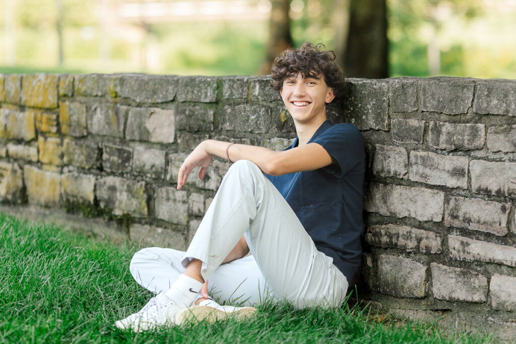 A boy leaning against a wall during his senior session at North Bank Park.